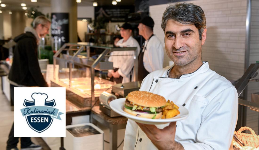 Ein Koch präsentiert einen Burger auf einem Teller 