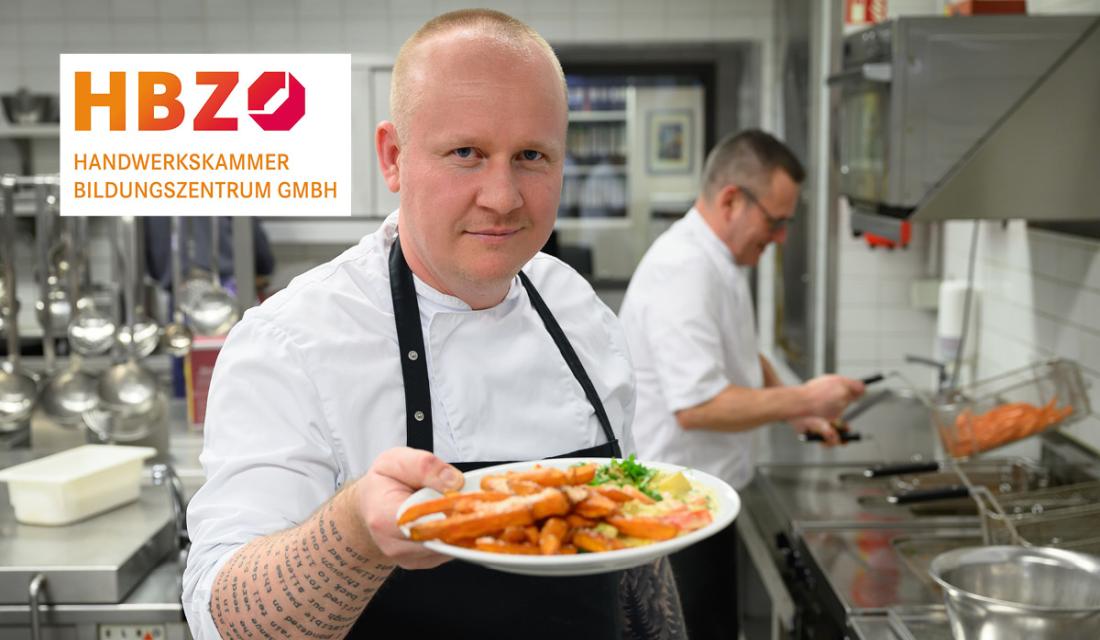 Ein Koch präsentiert einen Teller mit Essen