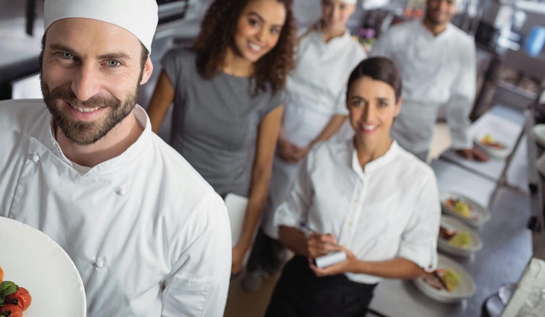 Ein Küchenteam lächelt in die Kamera