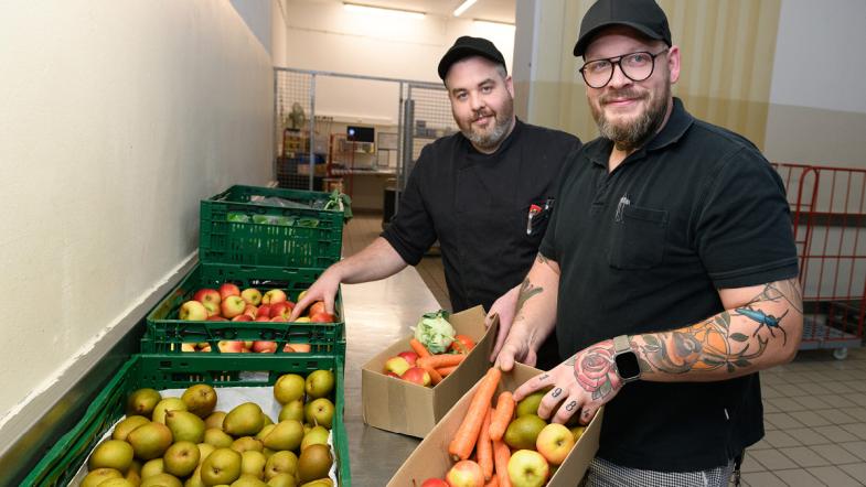 Zwei Mitarbeiter der Kantine mit Obstkisten